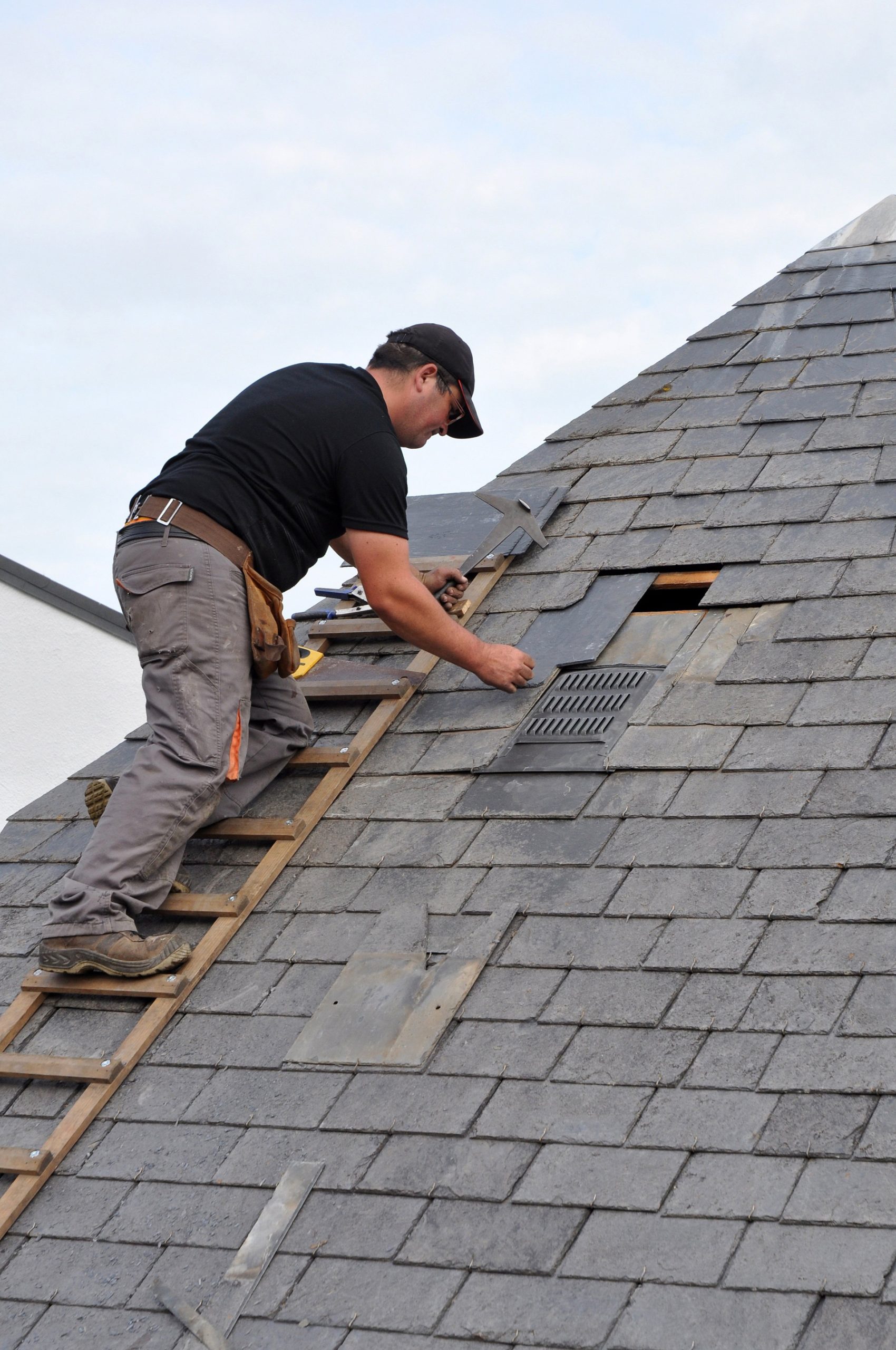Roofer working on installing slate roof