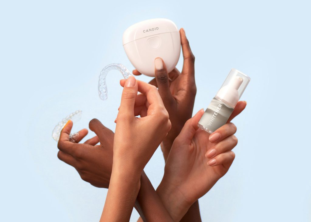 Hands holding up gum shield and dentist tools